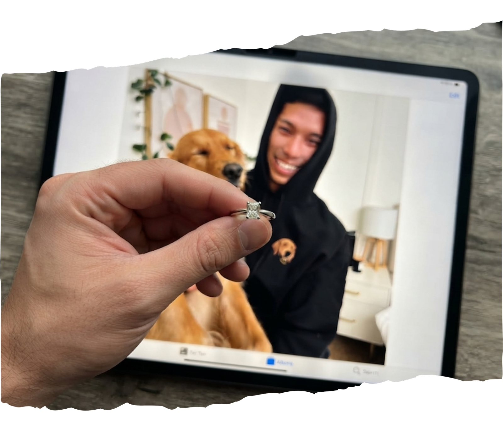 A hand holding a custom radiant-cut memorial diamond ring in front of a tablet screen displaying a happy dog and owner, representing a rescue pet tribute keepsake.