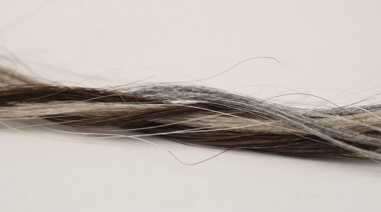 Close-up of coloured and grey strands on a plain surface