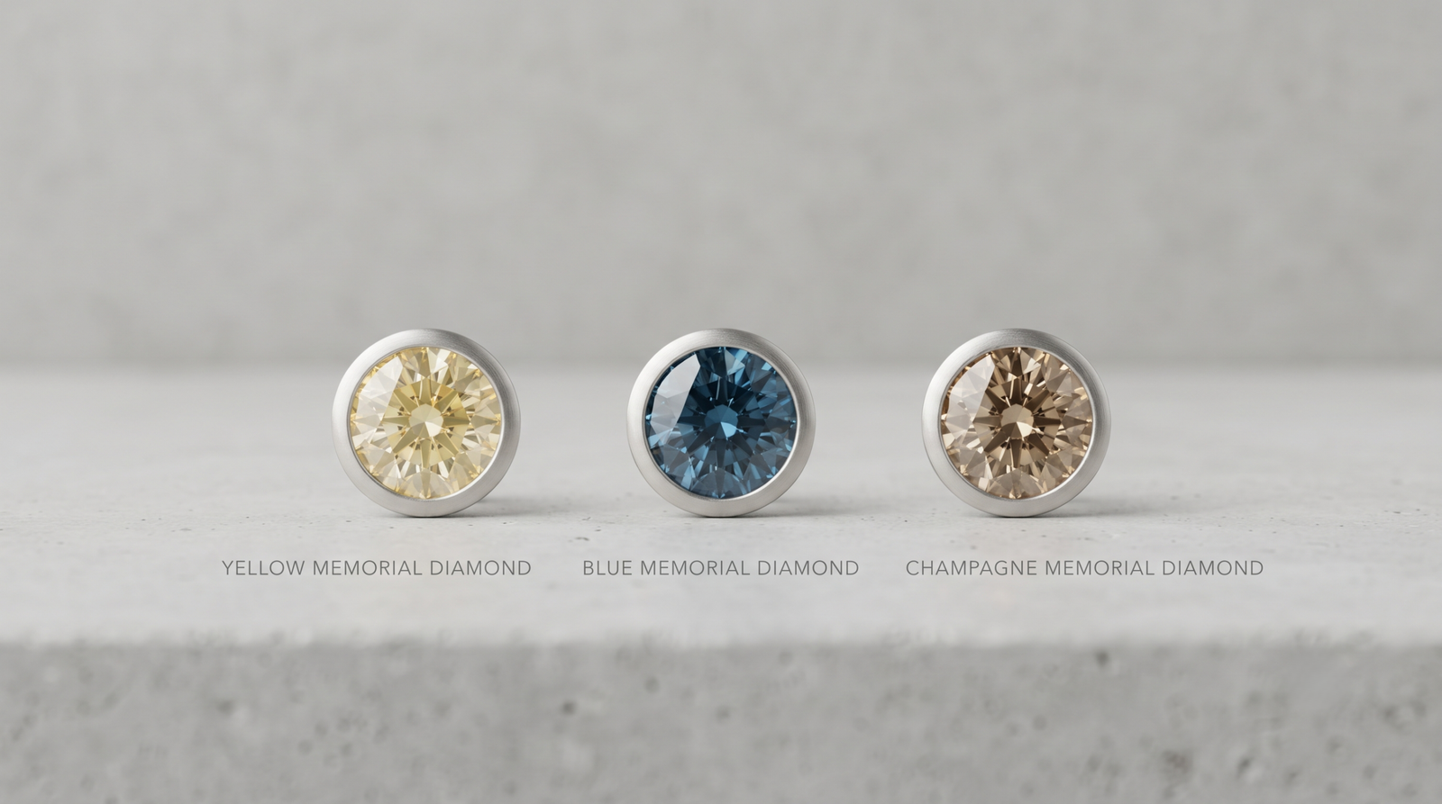 Three lab-grown memorial diamonds in yellow, blue and champagne tones side by side under even daylight