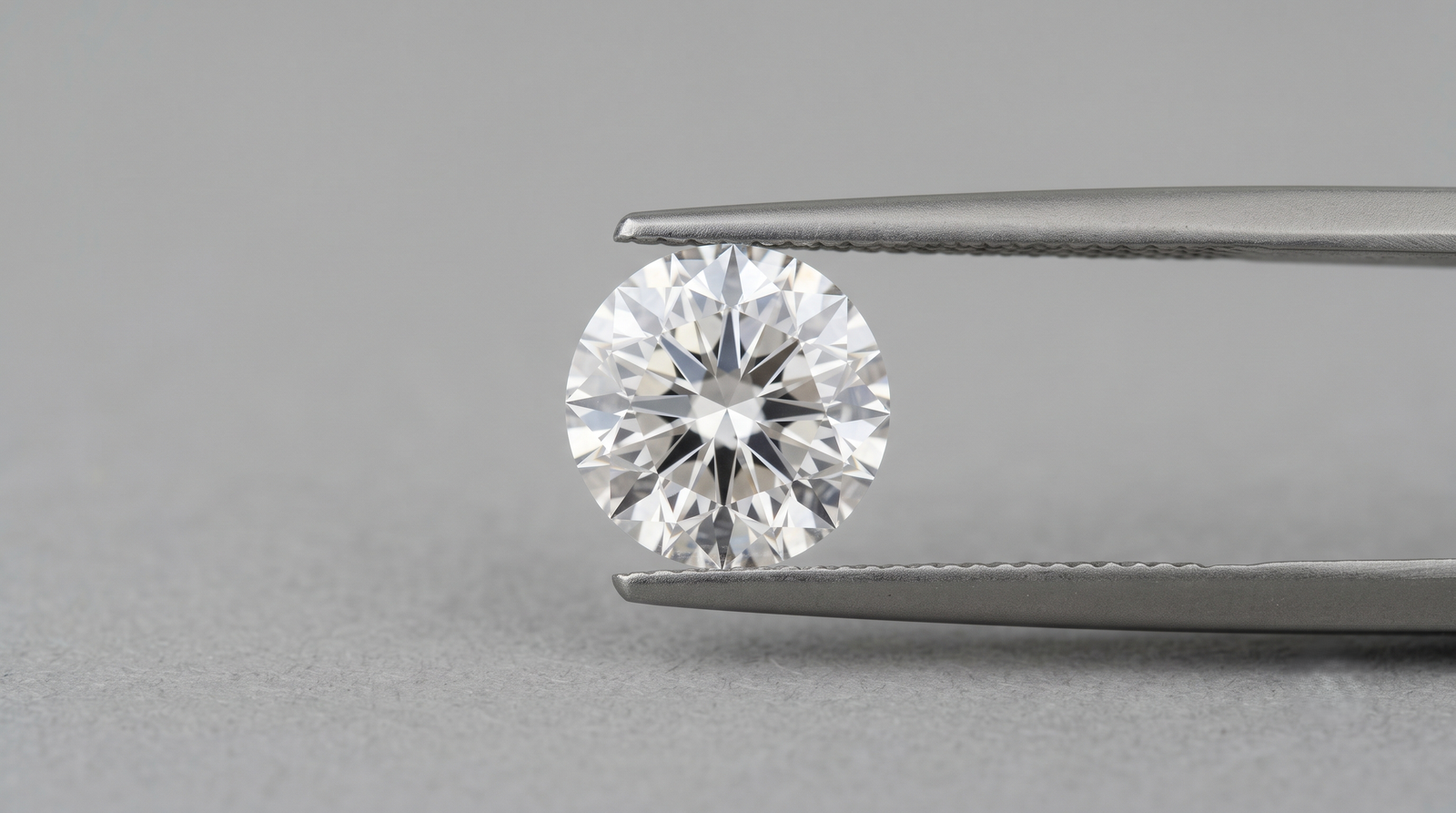 Loose lab-grown memorial diamond grown from cremated ashes held in tweezers 