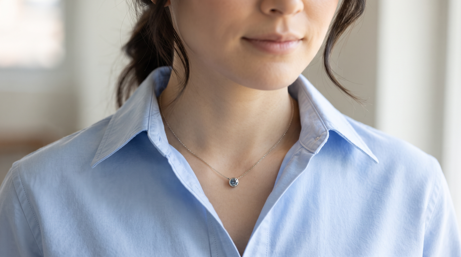 Simple memorial diamond pendant worn at the neckline, under a collar